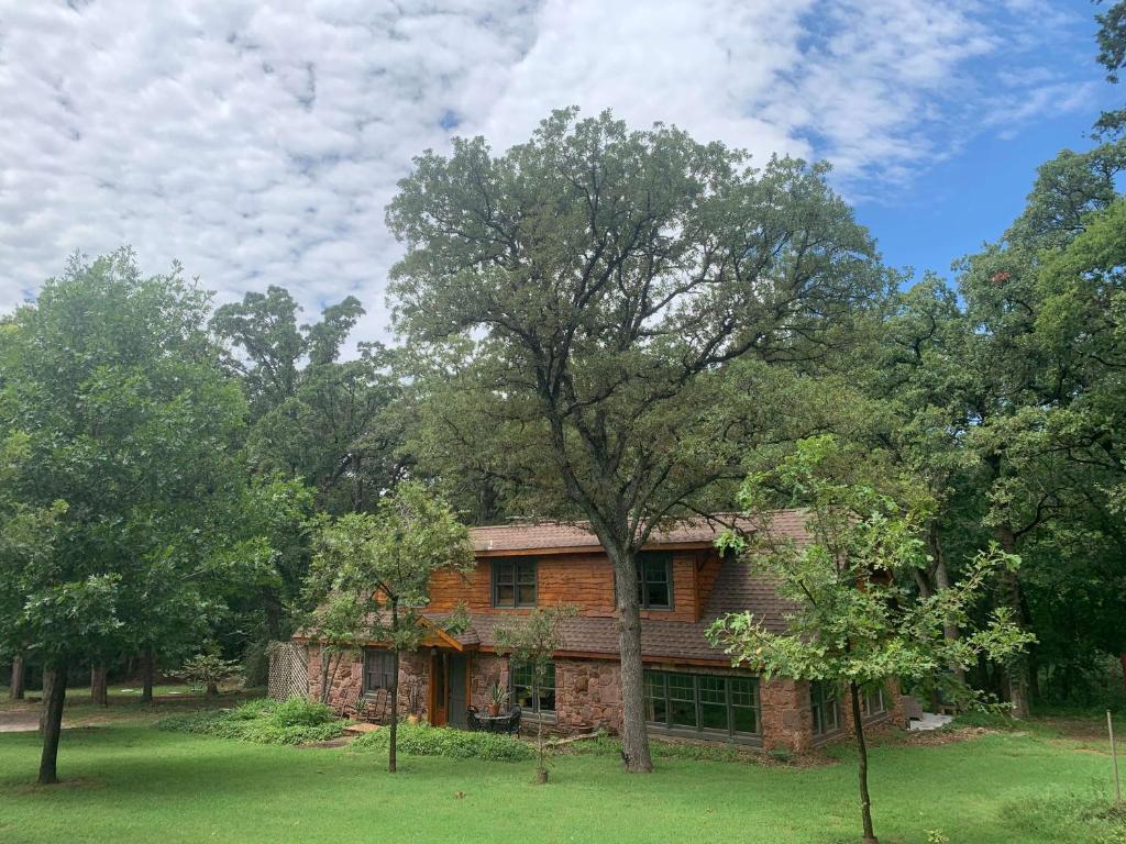 an old brick house in the middle of trees at The Gate House Cozy Christmas Cabin In Edmond in Edmond