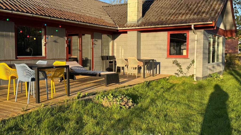 eine Terrasse mit Stühlen und einem Tisch auf einem Haus in der Unterkunft Guest Home Oksbøl in Oksbøl