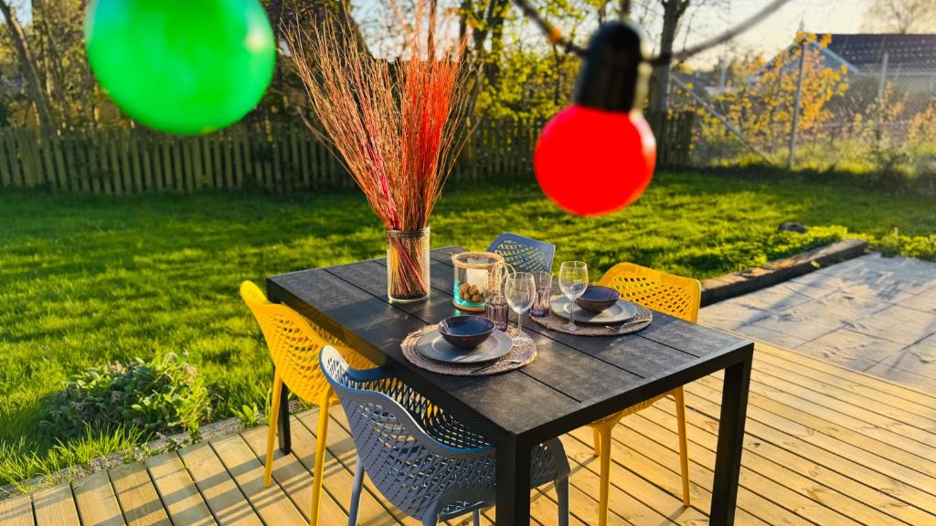 ein schwarzer Tisch mit Stühlen und einer Vase und Gläsern in der Unterkunft Guest Home Oksbøl in Oksbøl