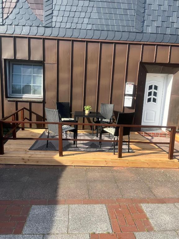 a wooden deck with a table and chairs on it at FeWo Landkirchen 2 in Fehmarn