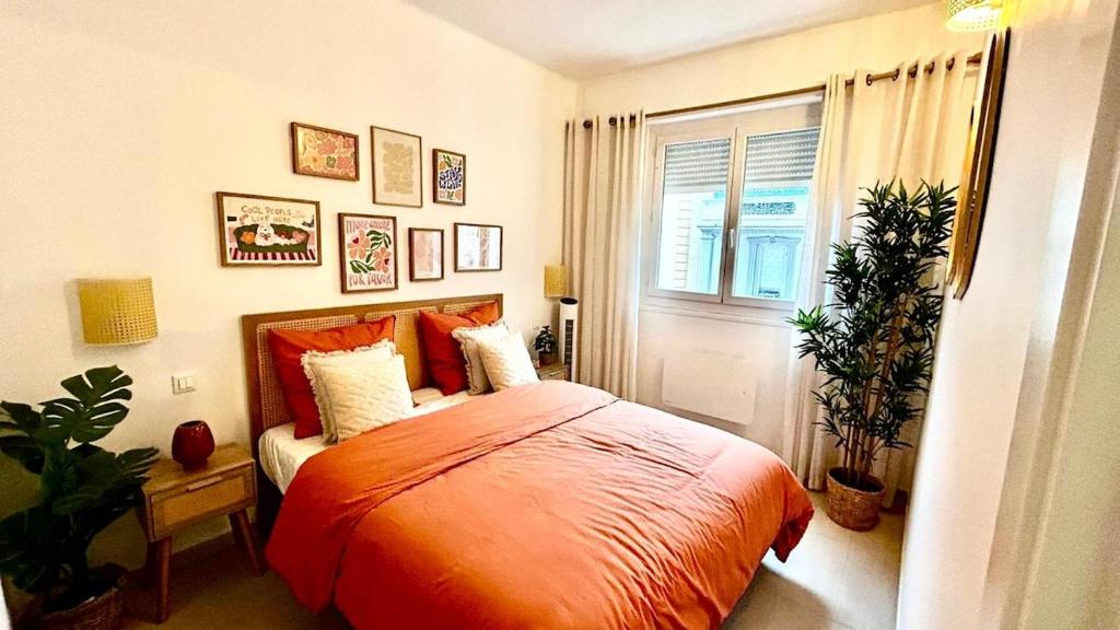 - une chambre avec un lit doté d'une couette en orange et d'une fenêtre dans l'établissement Chic & cosy proche mer, à Nice
