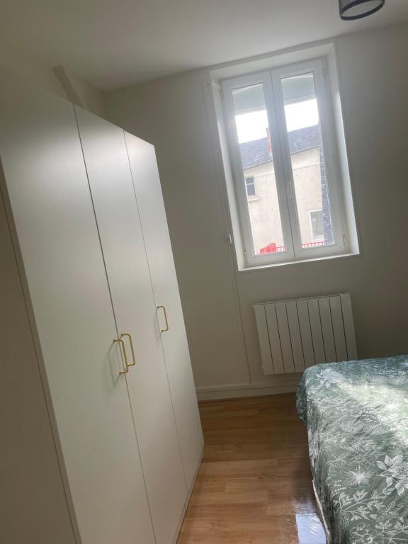 - une chambre avec une armoire blanche et une fenêtre dans l'établissement centre ville Bourges, à La Celle-sous-Gouzon