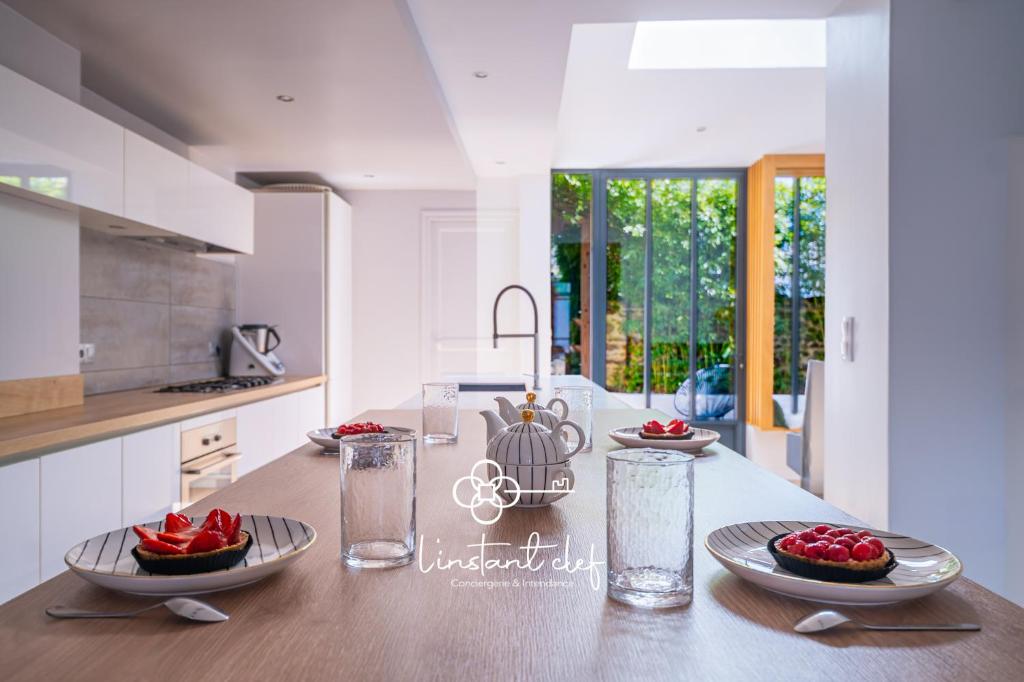 - une cuisine avec une table et des assiettes de fruits dans l'établissement Charme au Mans - Jardin arboré & douceur de vivre, au Mans