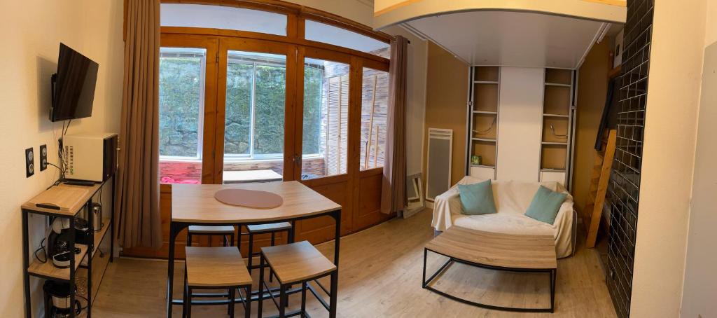 - un petit salon avec une table et des chaises dans l'établissement Studio au centre de Cauterets, à Cauterets