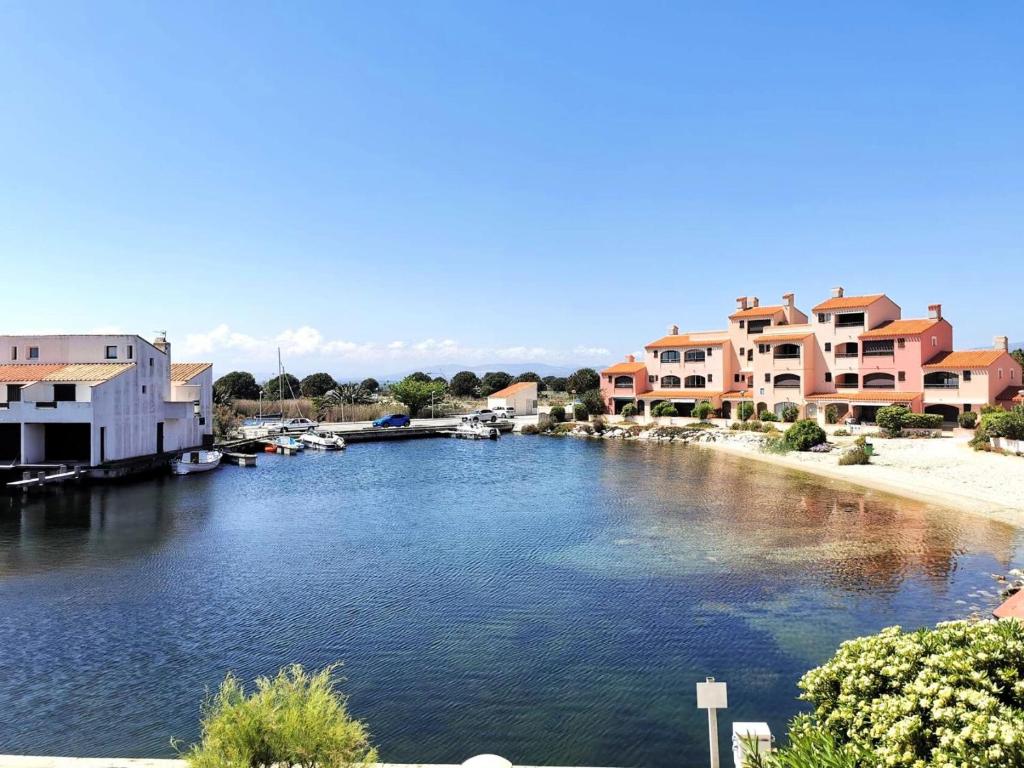 une rivière avec des maisons et des bateaux dans une ville dans l'établissement Résidence Les Maisons De La Crique - APPT DEUX PIECES 4 couchages - LE BARCARES. Réf: 7MCR_15B3 MAE-0283, au Barcarès