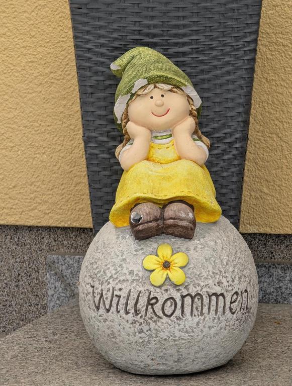 a figurine of a little girl sitting on a rock at Pension zum Reiterhof, Fewo 2 in Schmogrow