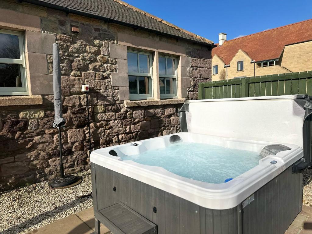 a hot tub in the backyard of a house at Greenfinch in Lucker