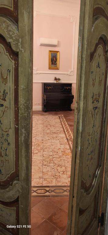 een open deur naar een kamer met een piano bij Art house Venusio luxury home in Napels