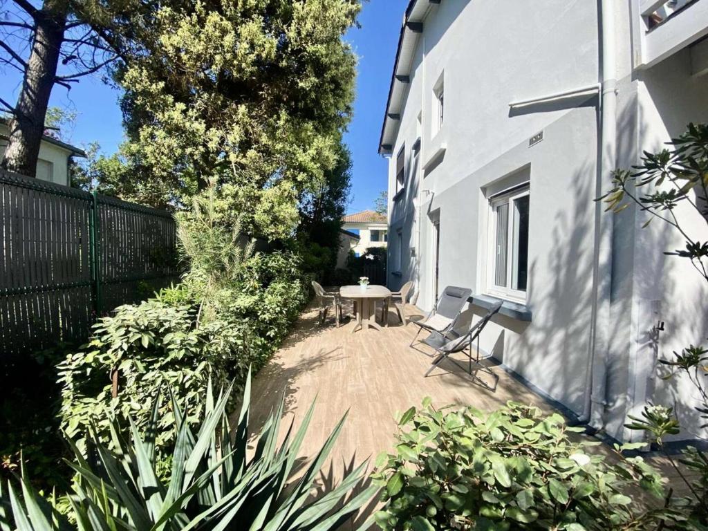 un patio avec une table et des chaises à côté d'un bâtiment dans l'établissement Résidence 040-soulac Sur Mer - 040 - Rez-de-chaussée classé 2 d'une charmante villa MAE-6081, à Soulac-sur-Mer