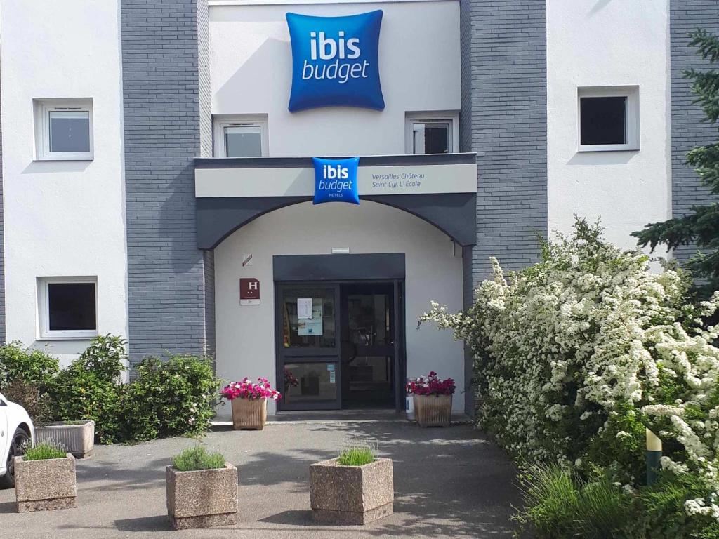 un bâtiment hospitalier avec un panneau indiquant les emplois ambulatoires dans l'établissement ibis budget Versailles Chateau Saint cyr l'Ecole, à Saint-Cyr-lʼÉcole
