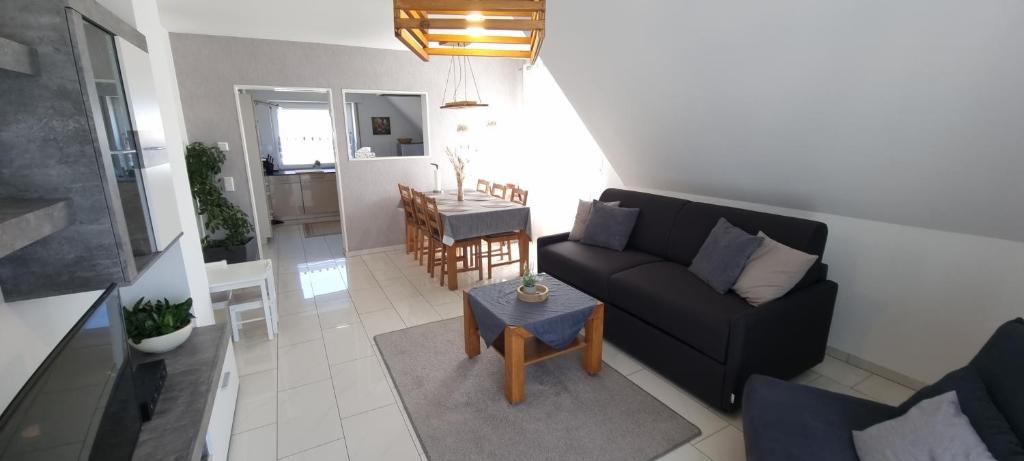 ビーレフェルトにあるApartmenthaus Çelik Bielefeld Süd Senneの黒いソファとテーブルのあるリビングルーム