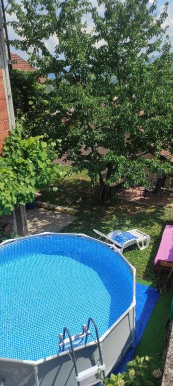an empty swimming pool in a yard with a tree at Guest House Lejla in Travnik