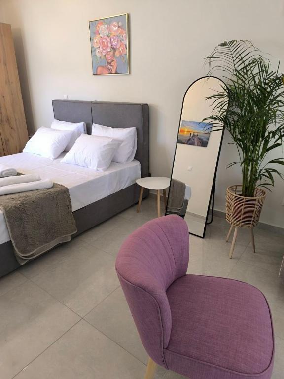a bedroom with a bed and a chair and a plant at Araucaria studio Manis in Mesochórion