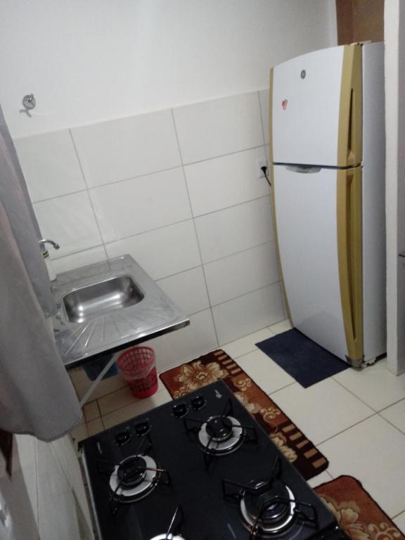 une cuisine avec une cuisinière et un réfrigérateur dans l'établissement Apartamento com área de lazer completa!, à Valparaíso de Goiás