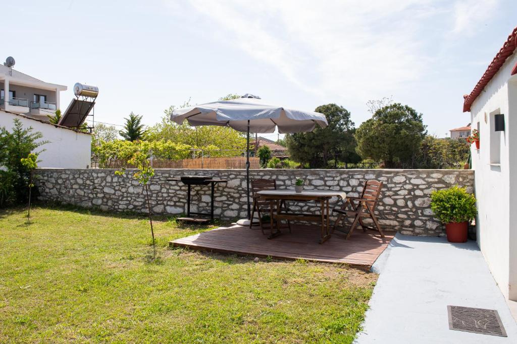 a patio with a table and an umbrella at Kentrikon Rooms III & Mint House in Limenaria