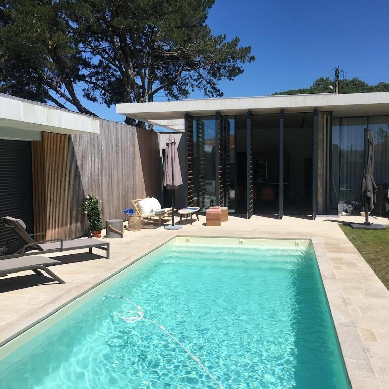 une piscine devant une maison dans l'établissement Villa paloma, à Gujan-Mestras