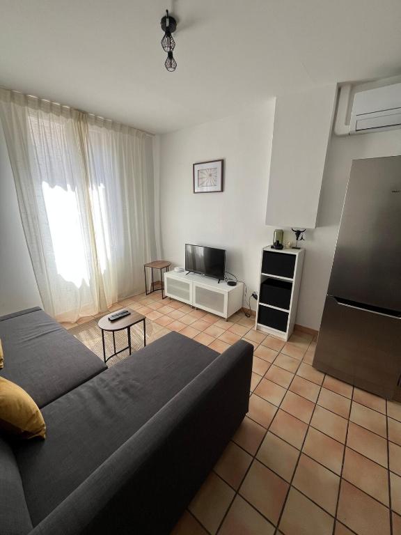 un salon avec un canapé et une télévision dans l'établissement Appartement rénové à 5min de la Comédie - Clim - 4 personnes, à Montpellier