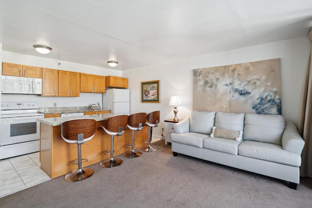 a living room with a couch and a kitchen at Oceanview 30th Floor Condo Just Steps from Waikiki Beach, Full Kitchen, Free Parking (13007) in Honolulu
