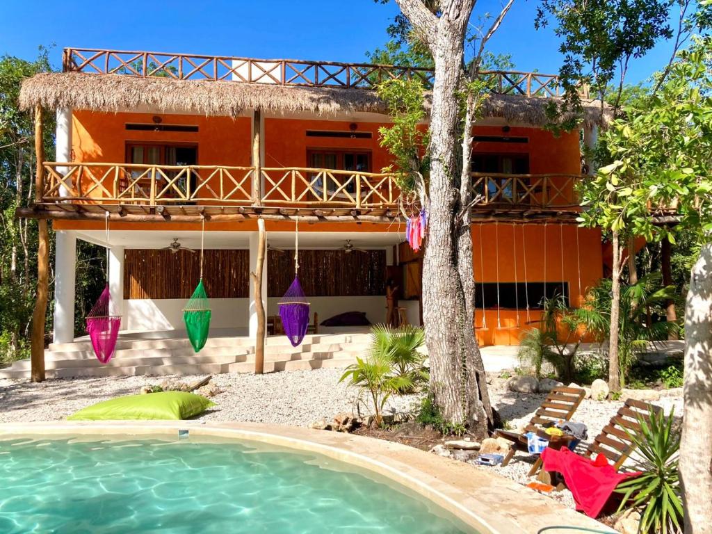 a house with a swimming pool in front of it at The Jungle House, Sacbé in Playa del Carmen