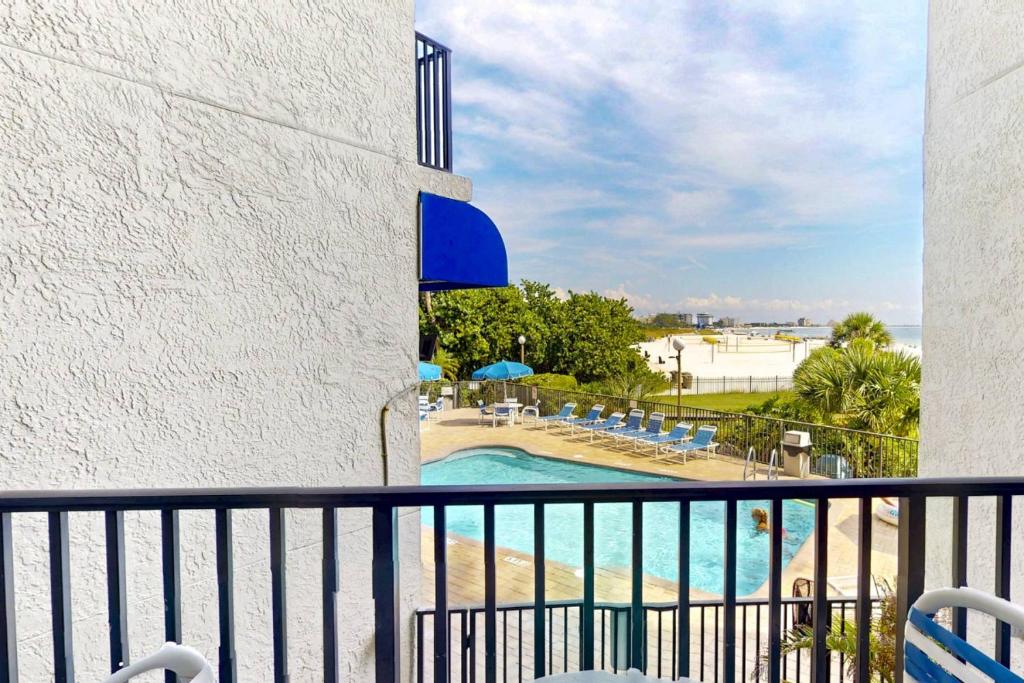 a balcony with a view of a swimming pool at 105 - Caprice Resort in St. Pete Beach