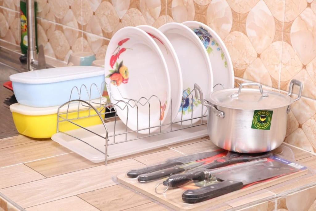 a kitchen counter with dishes and a pot on a shelf at Reliable Cosy Apartment 1 in Trofwi