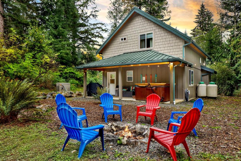 eine Gruppe von Stühlen, die um ein Feuer vor einem Haus herum sitzt in der Unterkunft 2 Kings, Fire Pit, Gameroom, EV charger, Dogs OK! in Glacier