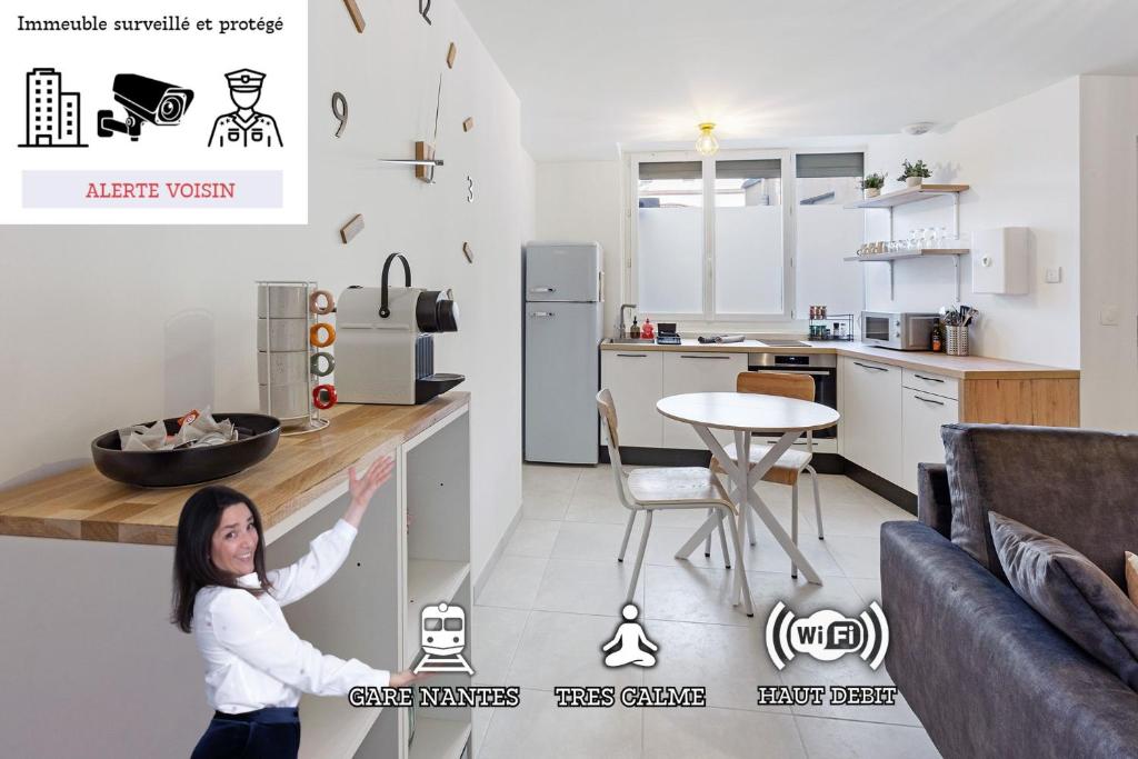 une femme debout dans une cuisine avec son bras en l'air dans l'établissement O terminus - T2 rénové - 5 min Gare et Jardin des plantes - Hyper Clame, à Nantes