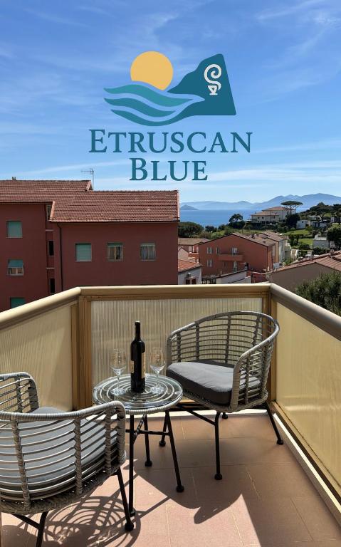 a patio with two chairs and a table with a bottle of wine at Etruscan Blue House in Piombino