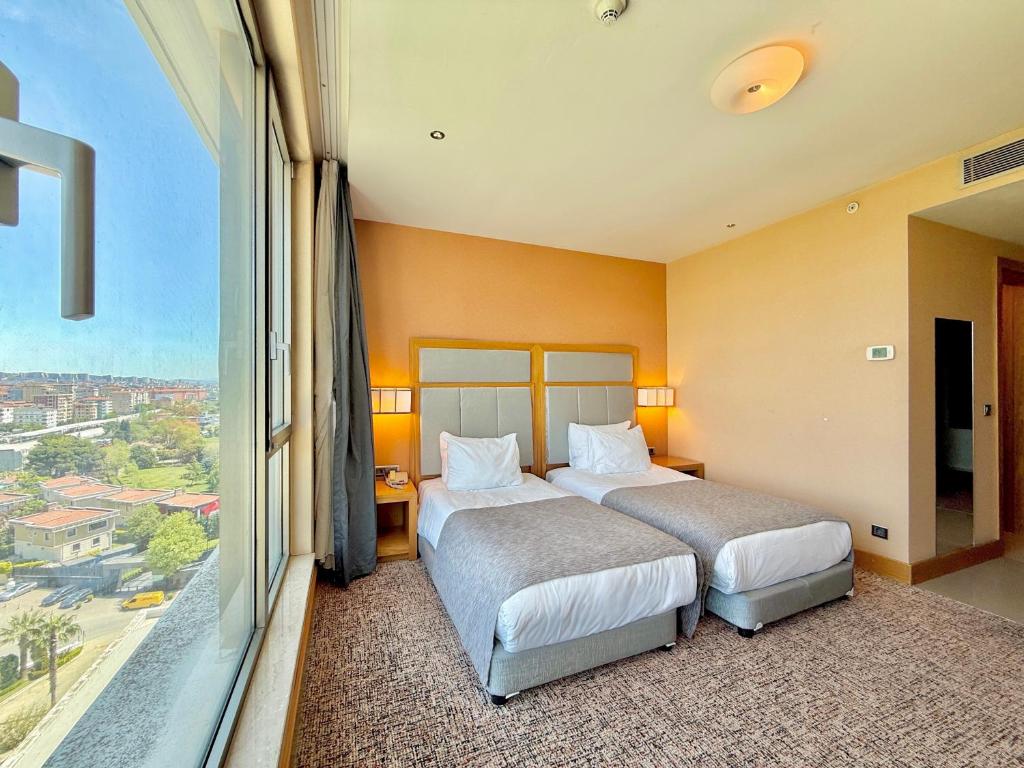 A bed or beds in a room at The Green Park Pendik