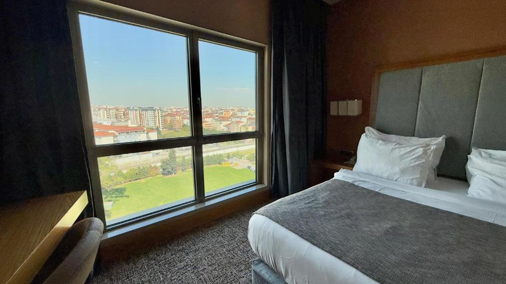 A bed or beds in a room at The Green Park Pendik
