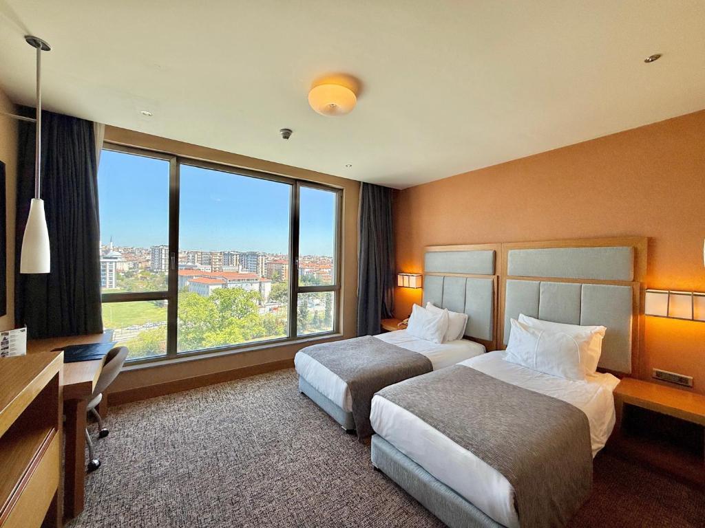 A bed or beds in a room at The Green Park Pendik