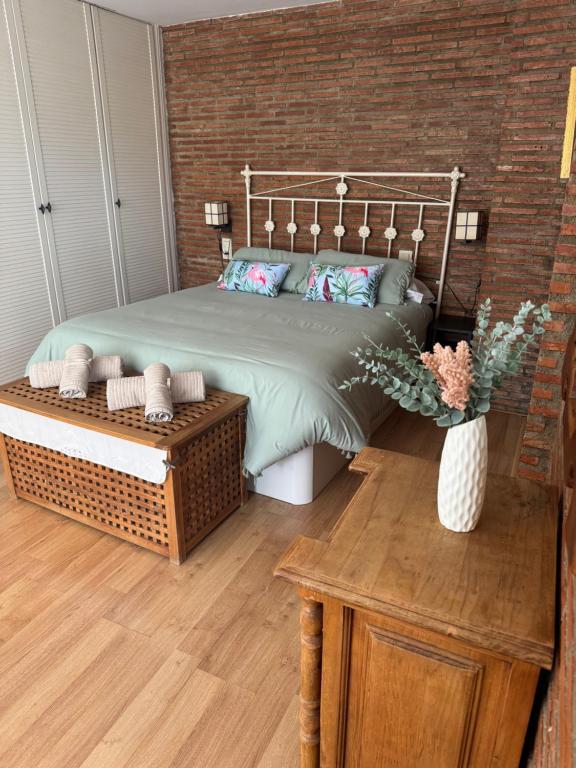 a bedroom with a bed and a wooden floor at Alcalá zona centro duplex in Alcalá la Real