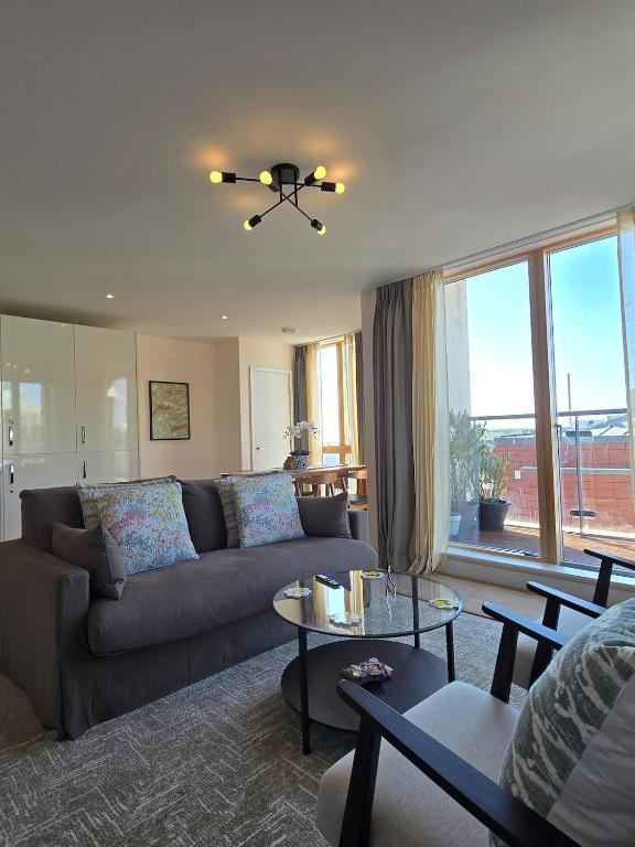 a living room with a couch and a table at Spacious seaside apartment with terrace, Kemptown in Brighton & Hove