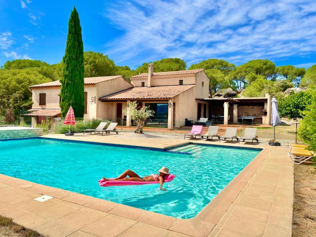 une femme flottant dans une piscine dans une maison dans l'établissement La Pastorale, à Vidauban