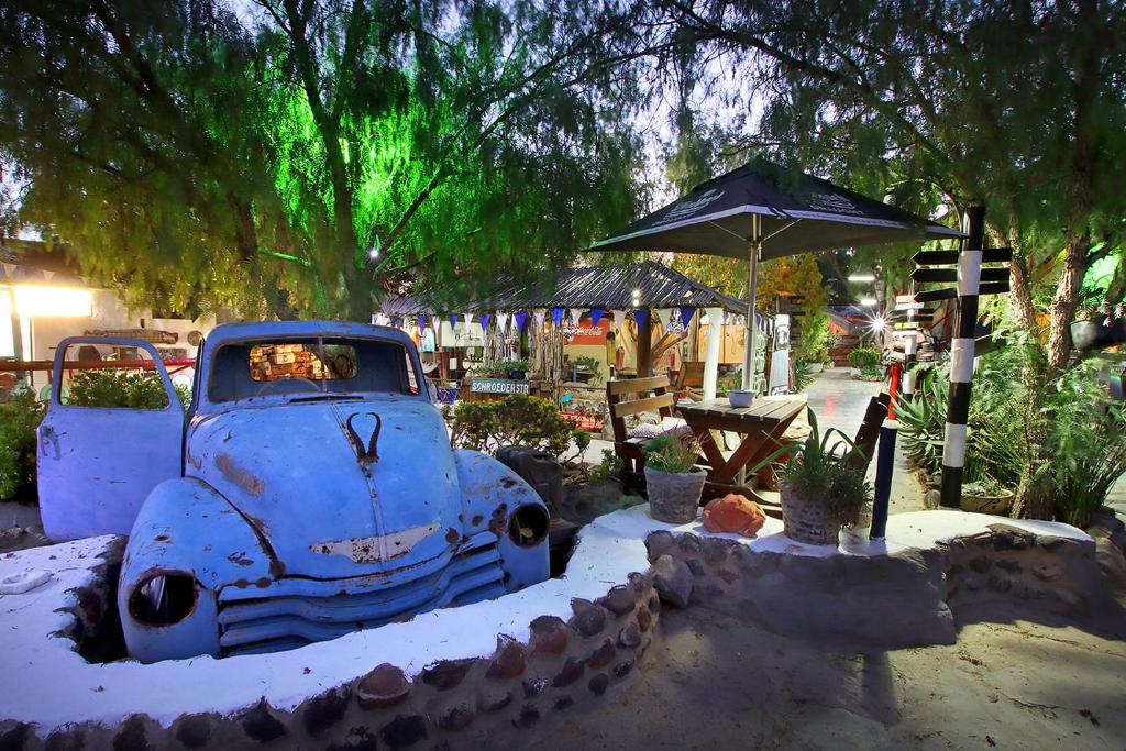 un vecchio camion blu parcheggiato nella neve con un ombrello di Ark Gastehuis and Williston Mall a Williston