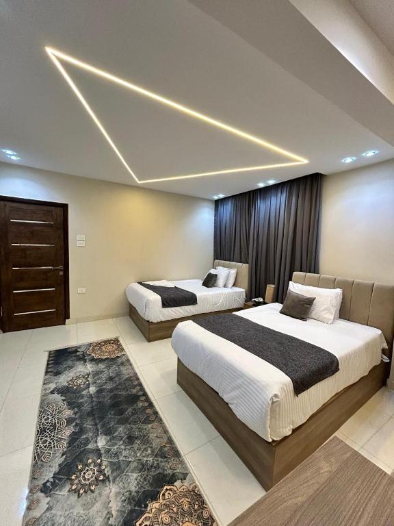 two beds in a hotel room with aception at Dima Pyramids View in Cairo