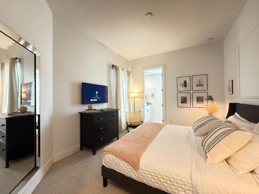 a bedroom with a bed and a dresser and a television at Magical 4BR Escape - Pet-Friendly, 9 Min to Disney in Orlando