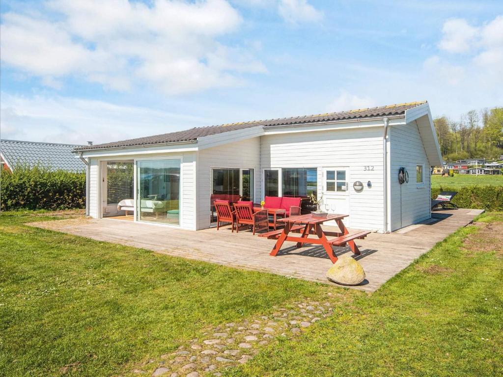 a picnic table in front of a white cottage at 4 person holiday home in Aabenraa-By Traum in Aabenraa