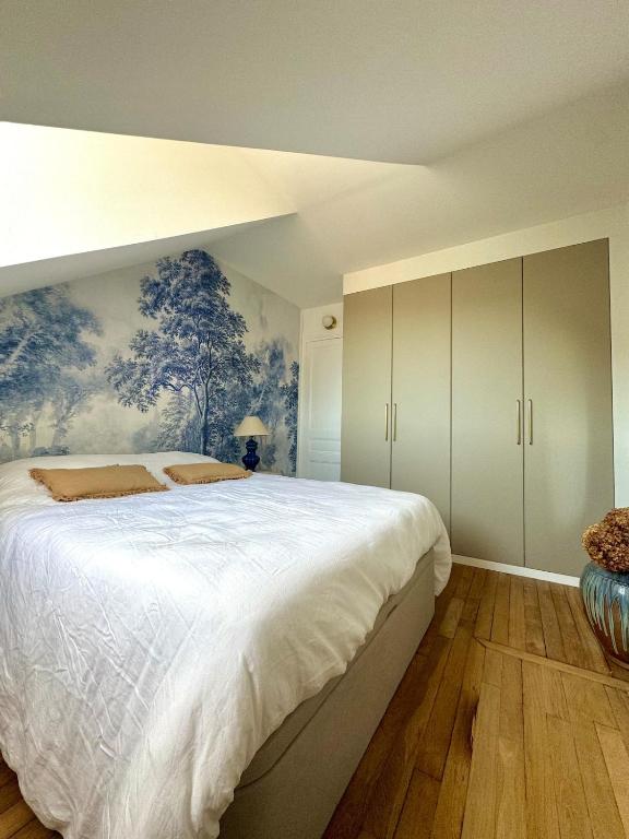 une chambre avec un grand lit avec un tableau au mur dans l'établissement Meudon Jewel Near Paris, à Meudon