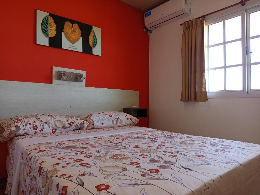 a bedroom with a bed with red walls and a window at Las Casuarinas in Federación