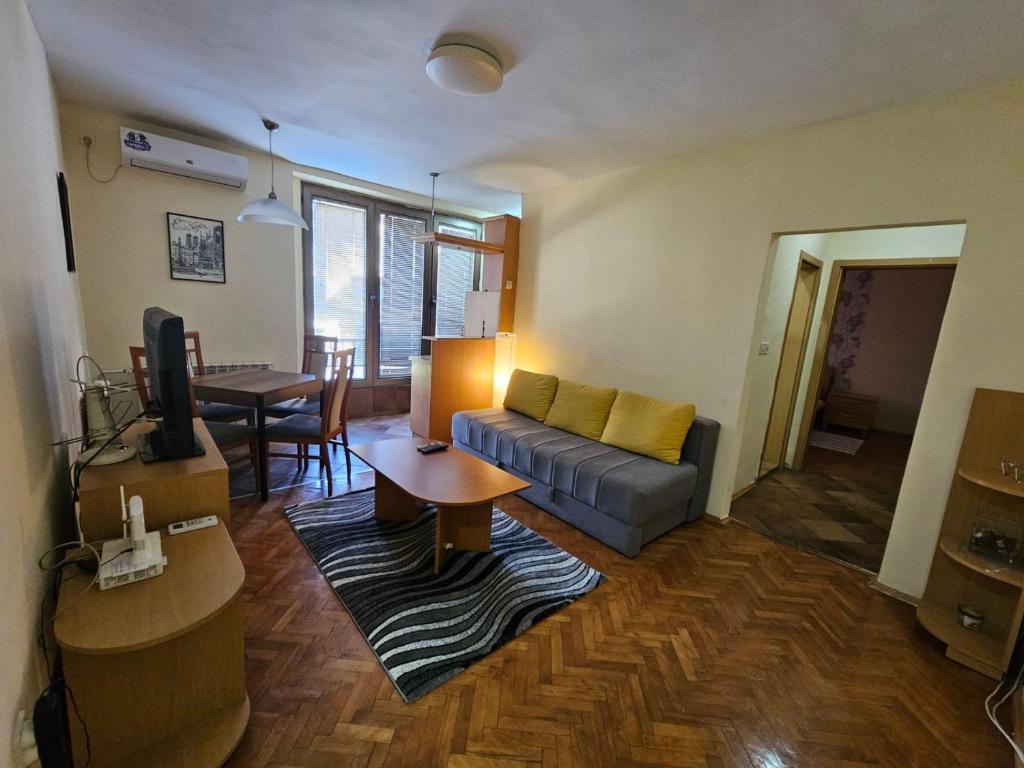 a living room with a couch and a table at Lovely square apartment Purple Velvet 43 Macedonia Stree in Skopje