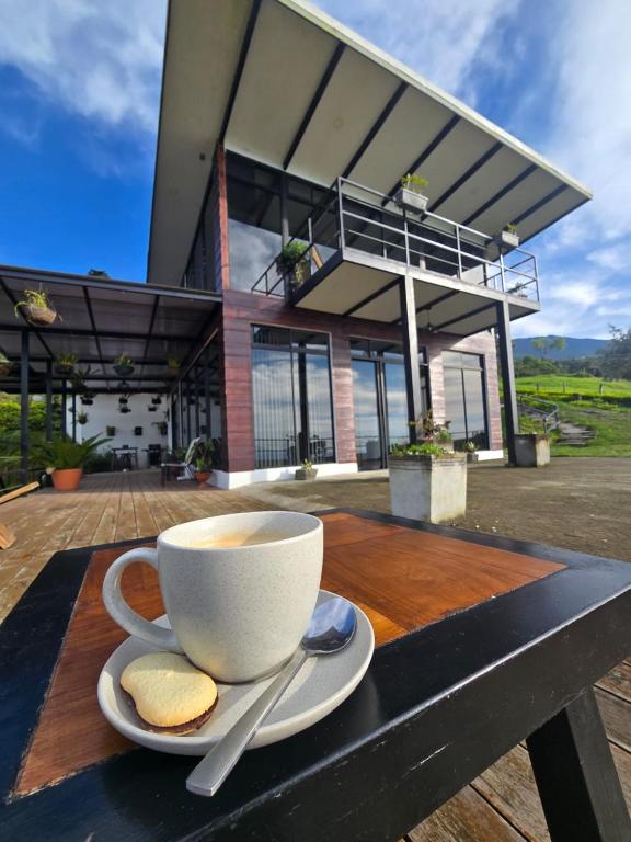 a cup of coffee sitting on a wooden table with cookies at Loft con hermosas vistas y Volcán Turrialba in Turrialba