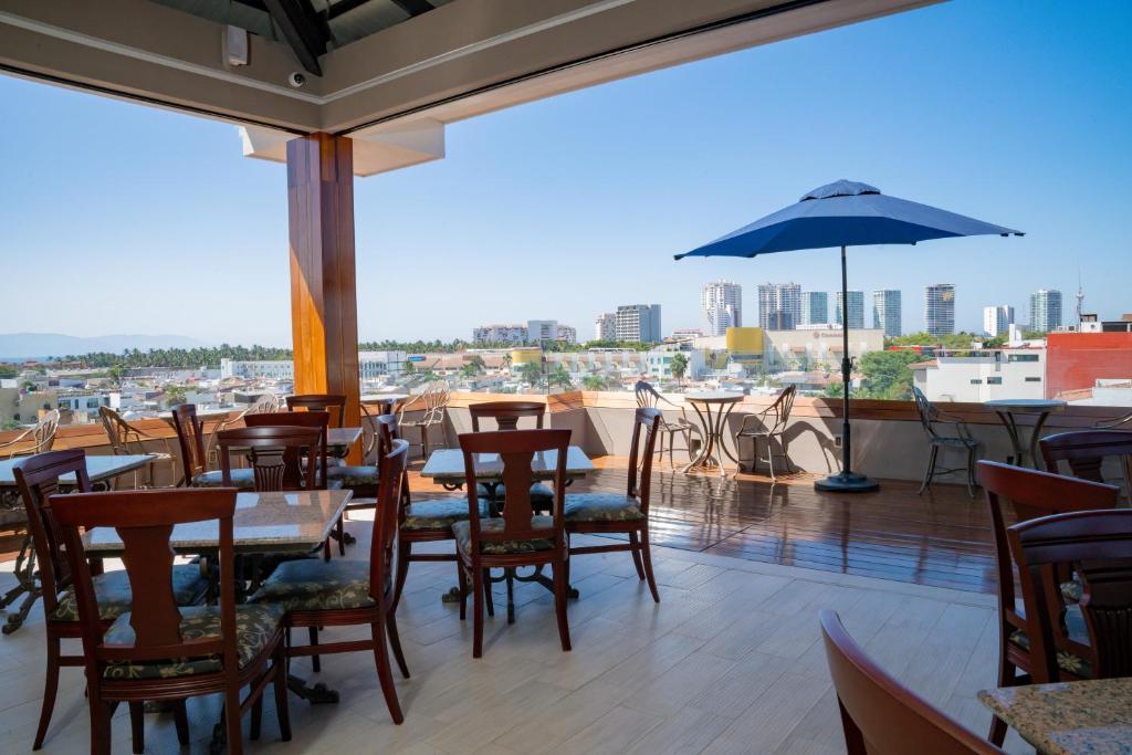 a restaurant with tables and chairs and an umbrella at Vallarta Live Hotel in Puerto Vallarta