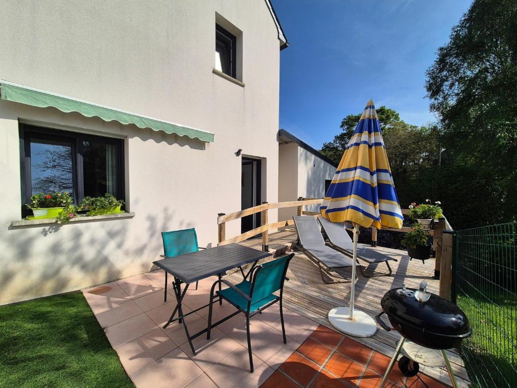 un patio con tavolo, ombrellone e sedie di Apartment in Erquy near Scenic Beaches a Erquy