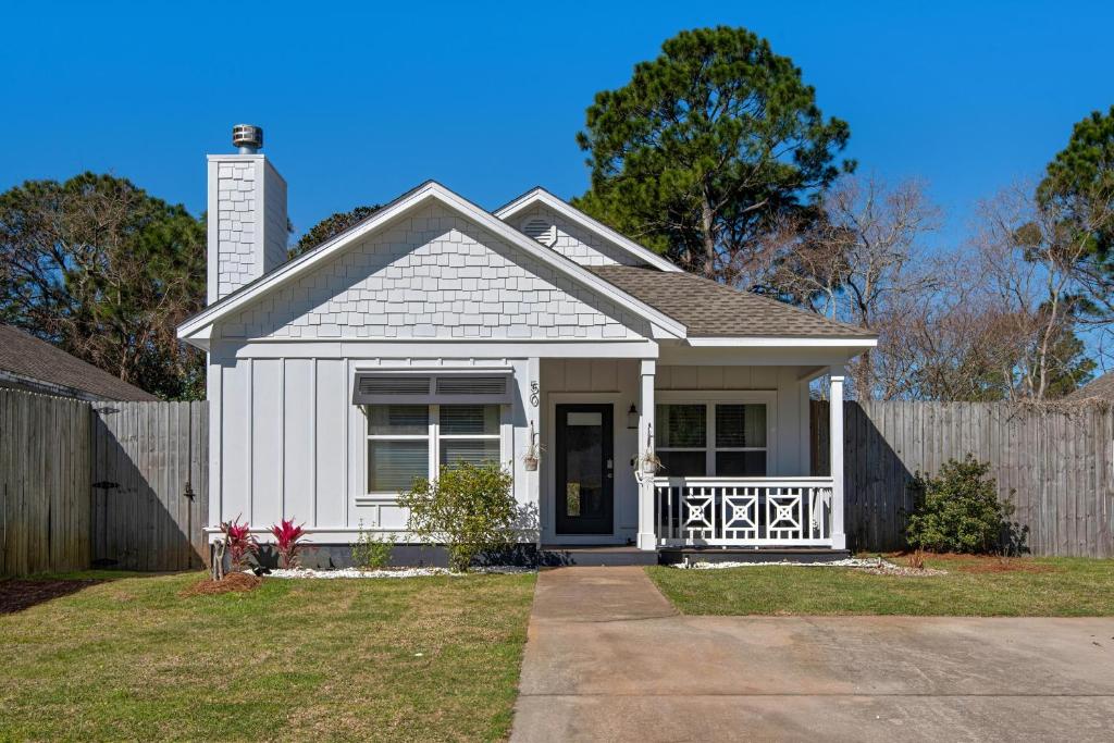 a small white house with a fence at Coastal Soul in Santa Rosa Beach