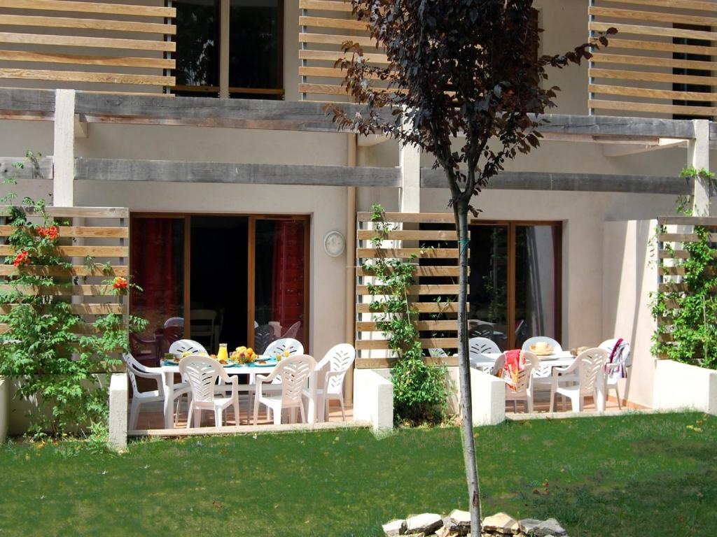 d'une terrasse avec des chaises et une table dans la cour. dans l'établissement Apartment La Closerie Barjac III, à Barjac