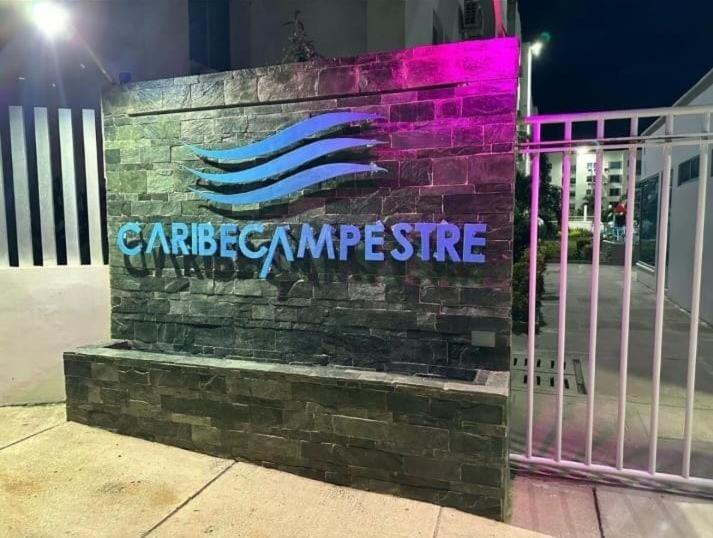 um sinal numa parede de tijolos ao lado de um portão em Acojedor apto en coveñas em Coveñas