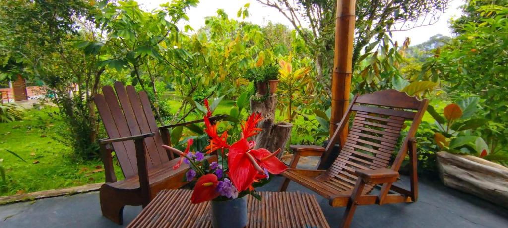 two chairs and a vase of flowers on a porch at Selva Mayo in Moyobamba