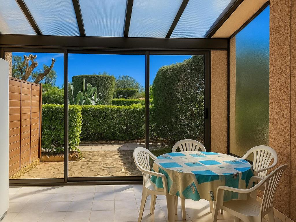 une véranda avec une table et des chaises ainsi qu'une terrasse dans l'établissement Appartement Rez-de-Jardin : Piscine Proche Plage - FR-1-732-8, à Argelès-sur-Mer