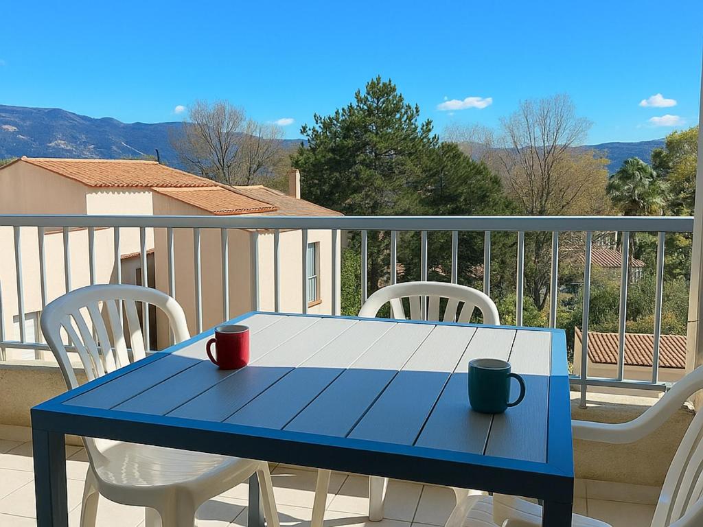 une table bleue et des chaises sur un balcon dans l'établissement Charmant T2 climatisé rénové, proche plage et commerces à Argelès-sur-Mer, avec balcon et parking privé - FR-1-732-68, à Argelès-sur-Mer